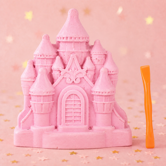 Pink Princess Castle with pointed towers and an arched door, shown beside the orange chisel included in the kit